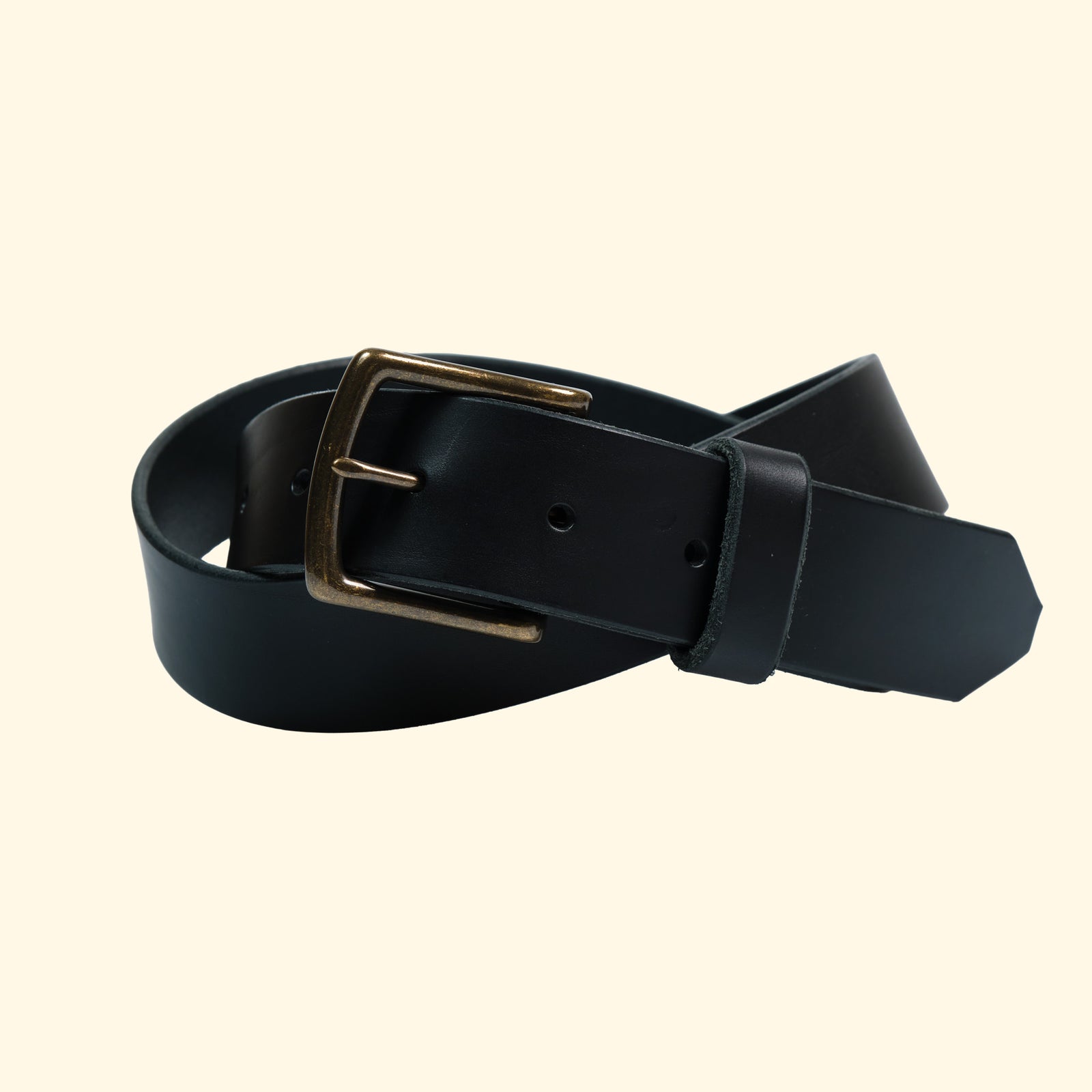 Der op belt in Rocky Nero mit matter Oberfläche und massiver Messingschnalle in schräger Ansicht gerollt dargestellt.