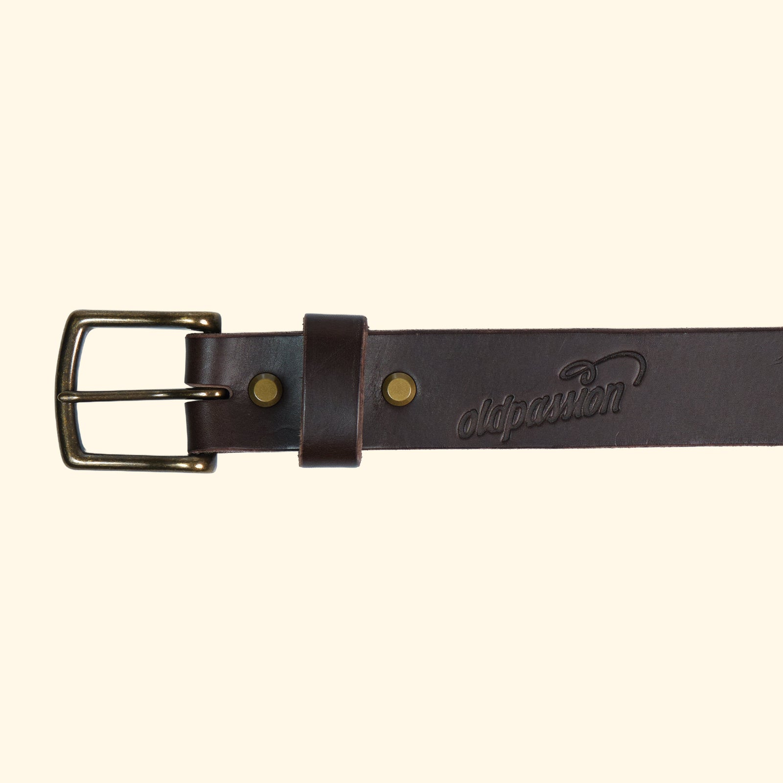 Detailansicht des op belt in Rocky Dark Brown mit antik-farbener Schnalle, feiner Logoprägung und glatter, dunkler Lederstruktur.