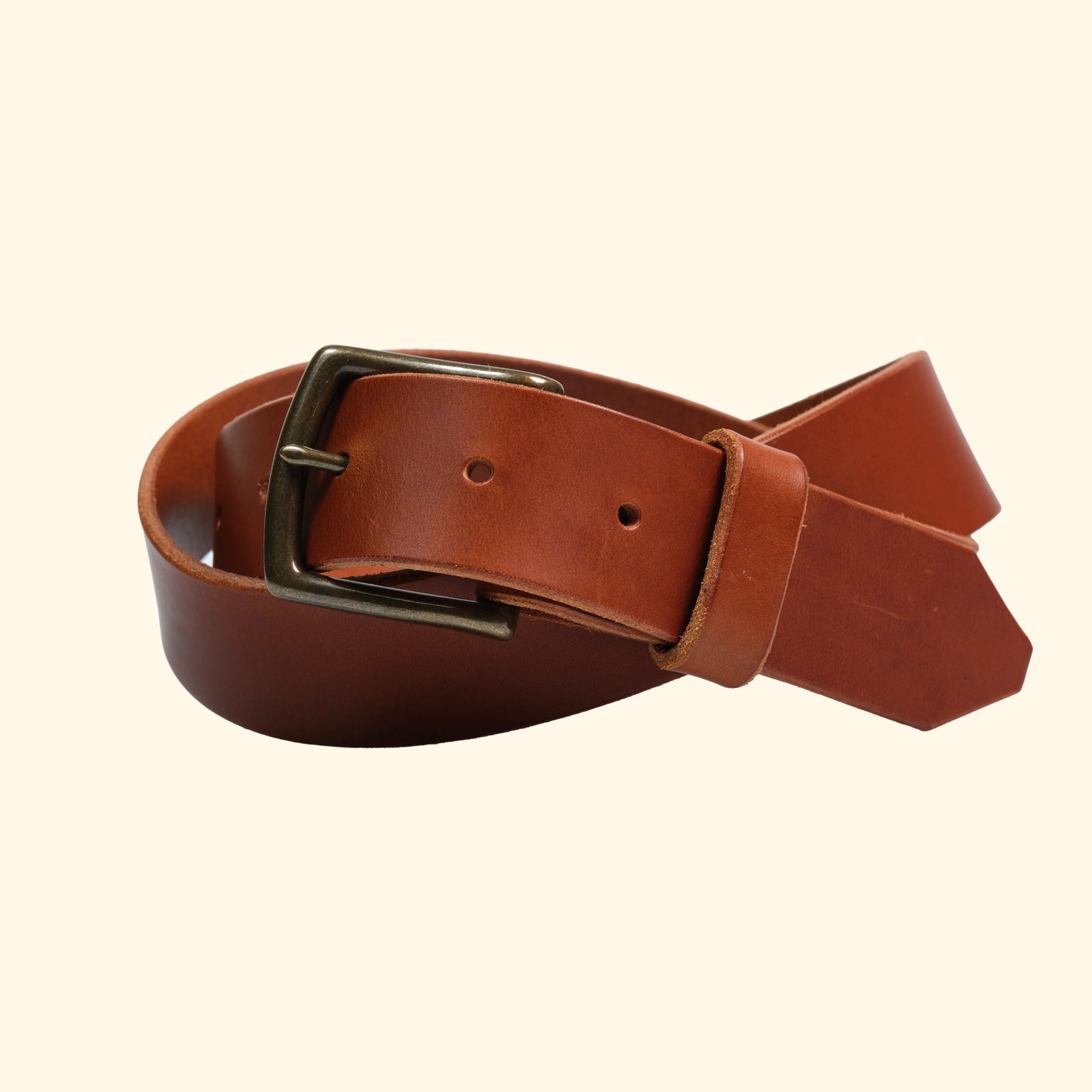 Massgefertigter Ledergürtel aus cognacfarbenem Rindsleder mit matter Oberfläche und silberfarbener Schnalle in Draufsicht.
