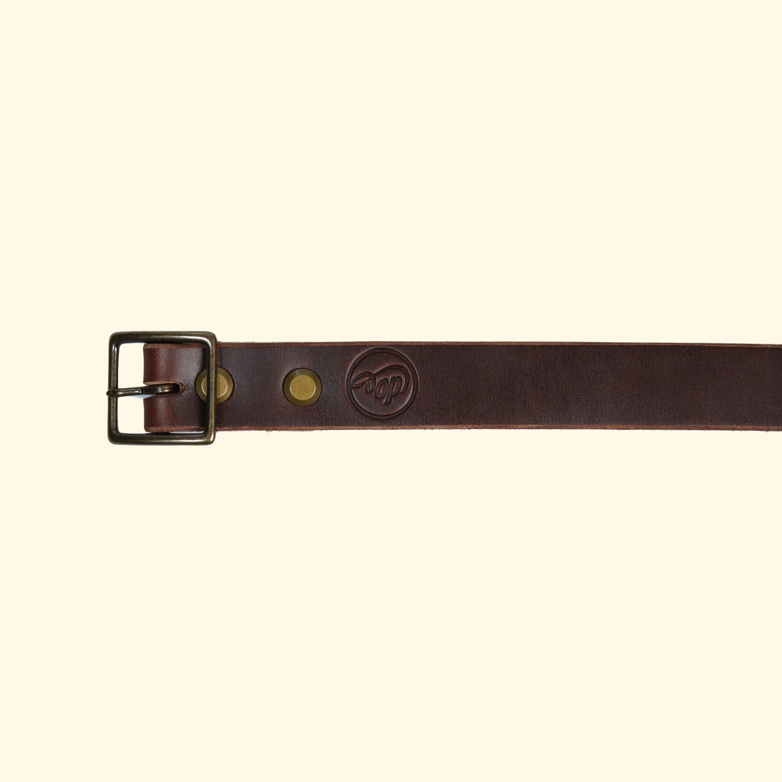 Aussenseite des oldpassion Gürtelmodells op belt slim aus Horween Chromexcel in Dunkelbraun mit antique-farbener Mittelsteg-Dornschliesse und geprägtem Markenlogo.