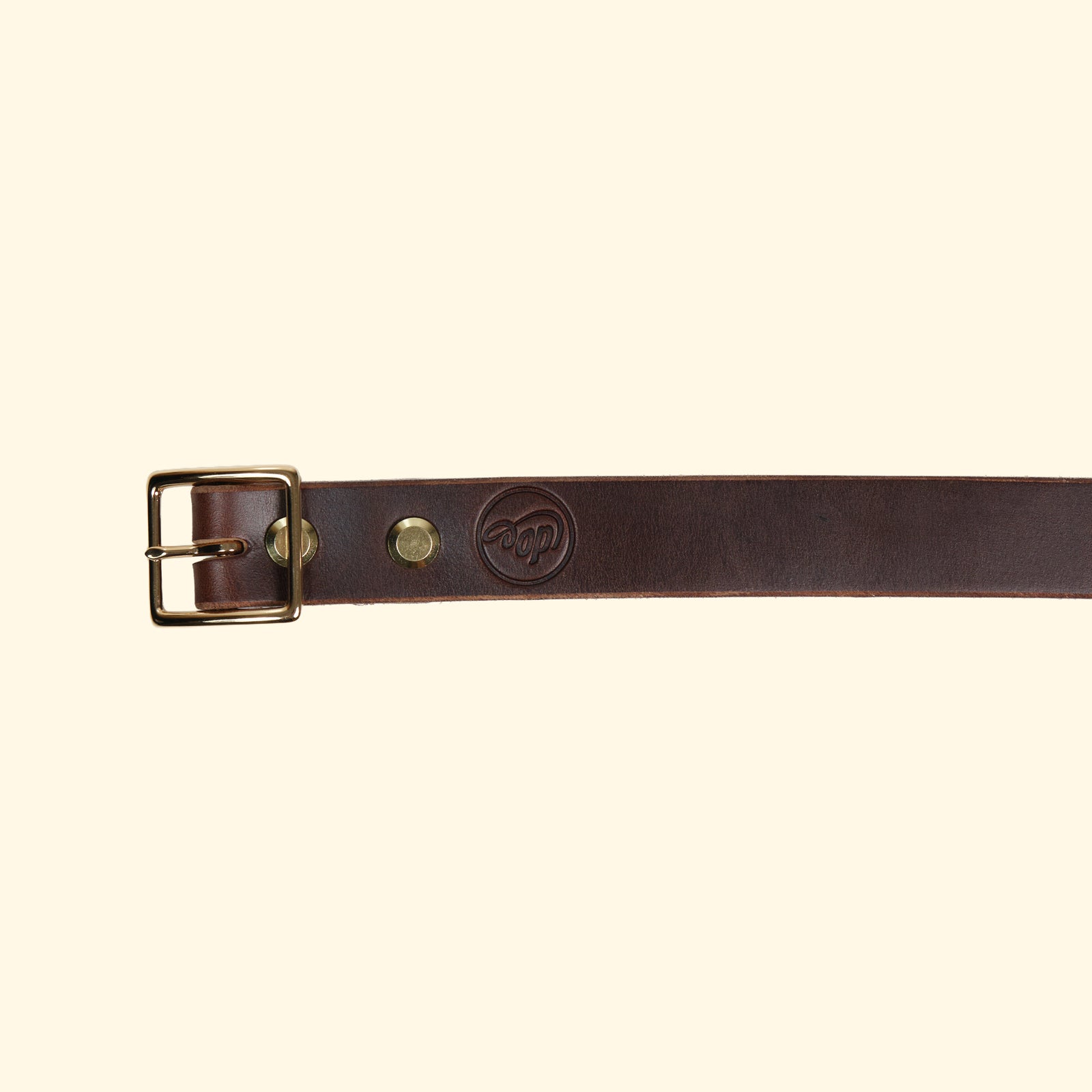 Aussenseite des oldpassion Gürtelmodells op belt slim aus Horween Chromexcel in Dunkelbraun mit goldfarbener Mittelsteg-Dornschliesse und geprägtem Logo.