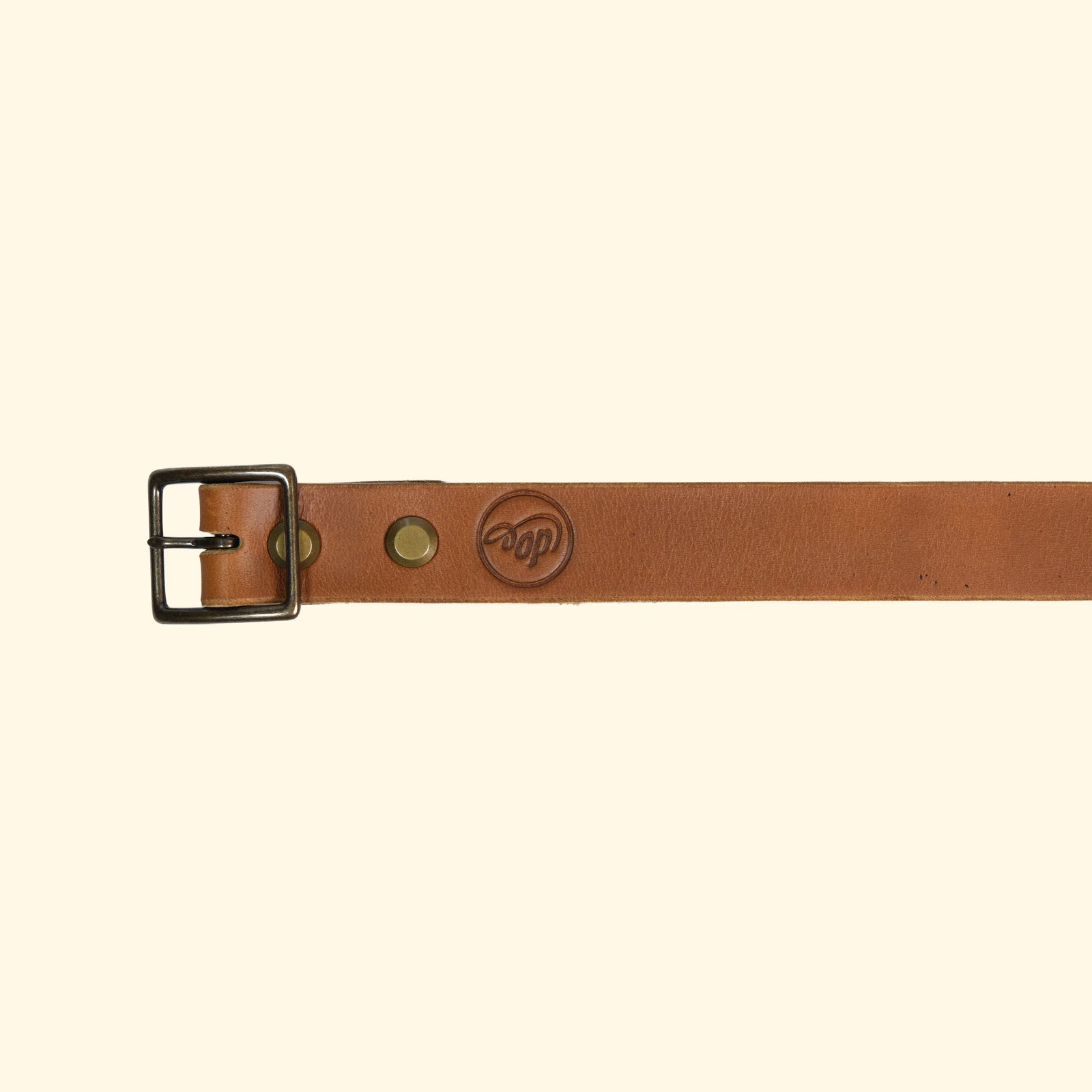 Nahaufnahme des oldpassion op belt slim aus Horween Cavalier Leder in Sunflower mit Antique-Schnalle und sichtbarem op-Logo als Prägung