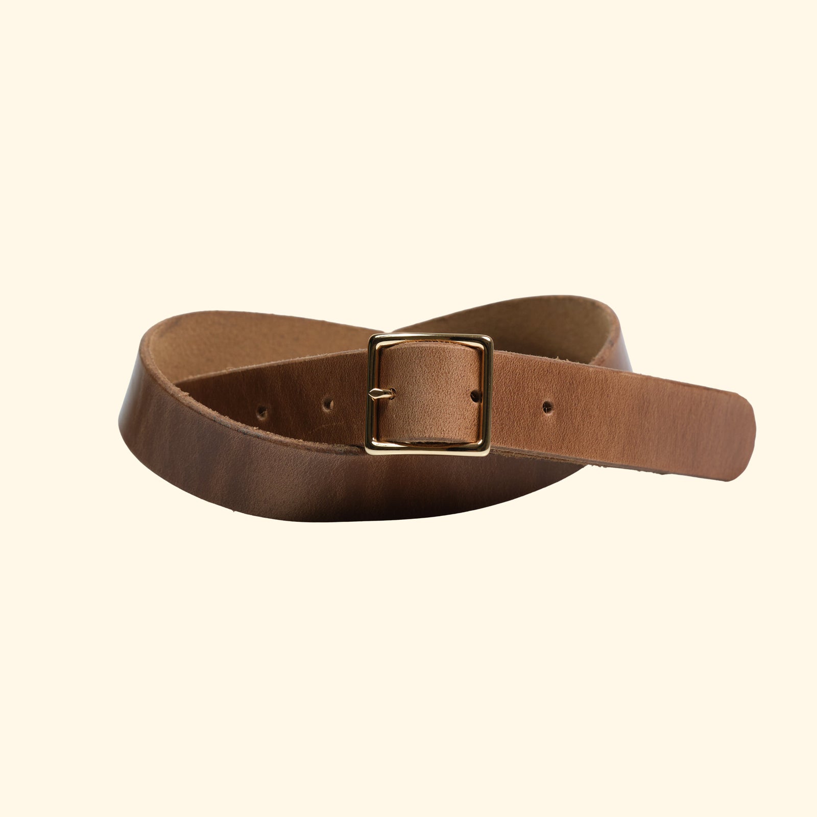 Schmaler Gürtel aus Horween Chromexcel Leder in Natural mit goldfarbener Mittelsteg-Dornschliesse, leicht gedreht dargestellt.