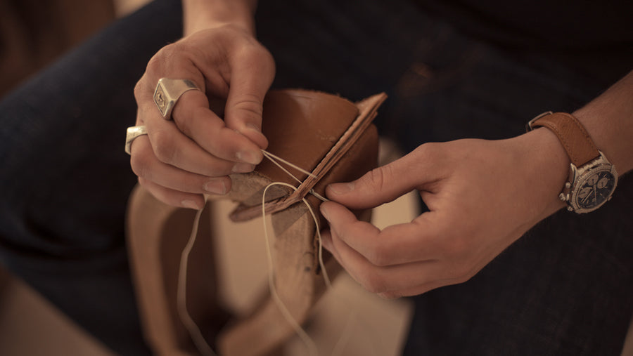 Hände beim Vernähen von Leder, Sattlerhandwerk