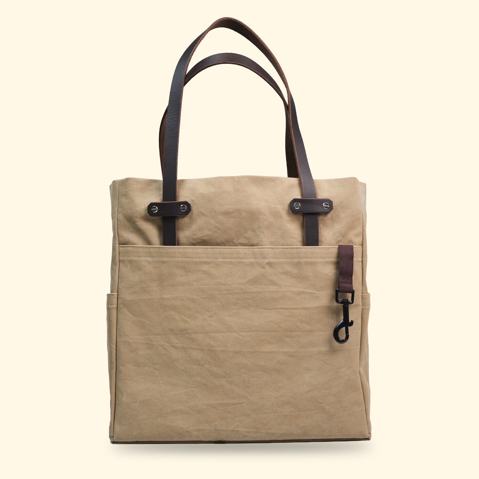 Canvas Tote Bag in Sandfarbe von oldpassion – klare Vorderansicht mit robusten Lederhenkeln und funktionalem Karabinerhaken, handgefertigt in der Schweiz.