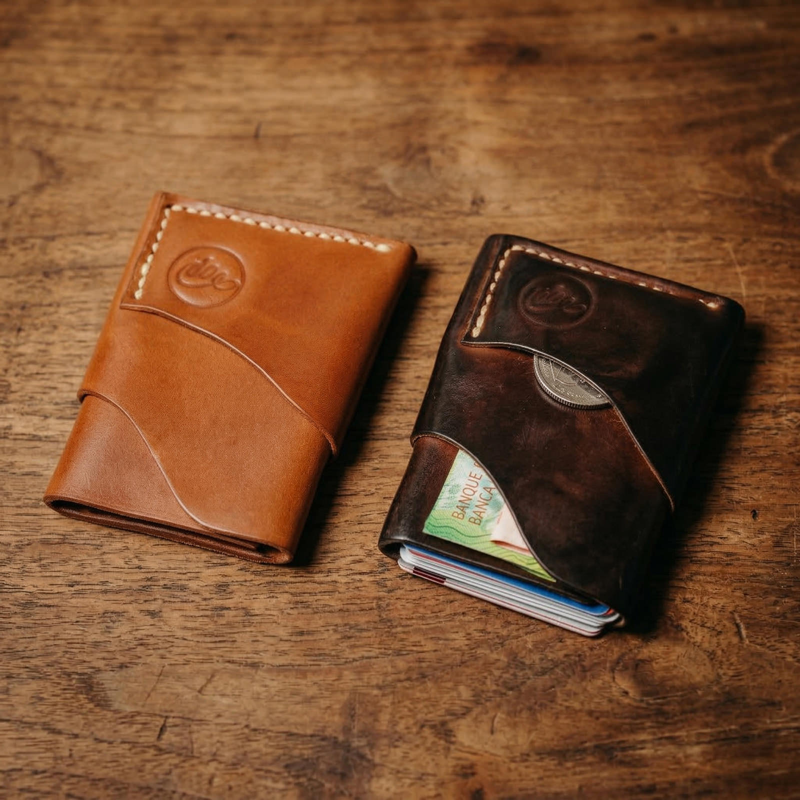 Zwei handgefertigte Burrito Wallets von oldpassion aus Shell Cordovan Pferdeleder in Whiskey und Dunkelbraun auf rustikalem Holz, die den edlen Glanz, den charaktervollen Vintage-Look und die hochwertige Verarbeitung zeigen.