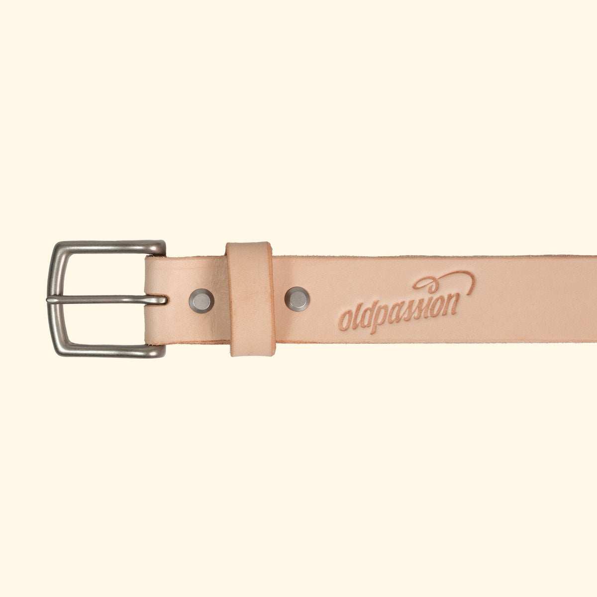 Nahaufnahme des vegetabil gegeerbten natural Ledergürtels mit silberner Schnalle und oldpassion-Prägung auf der Vorderseite.