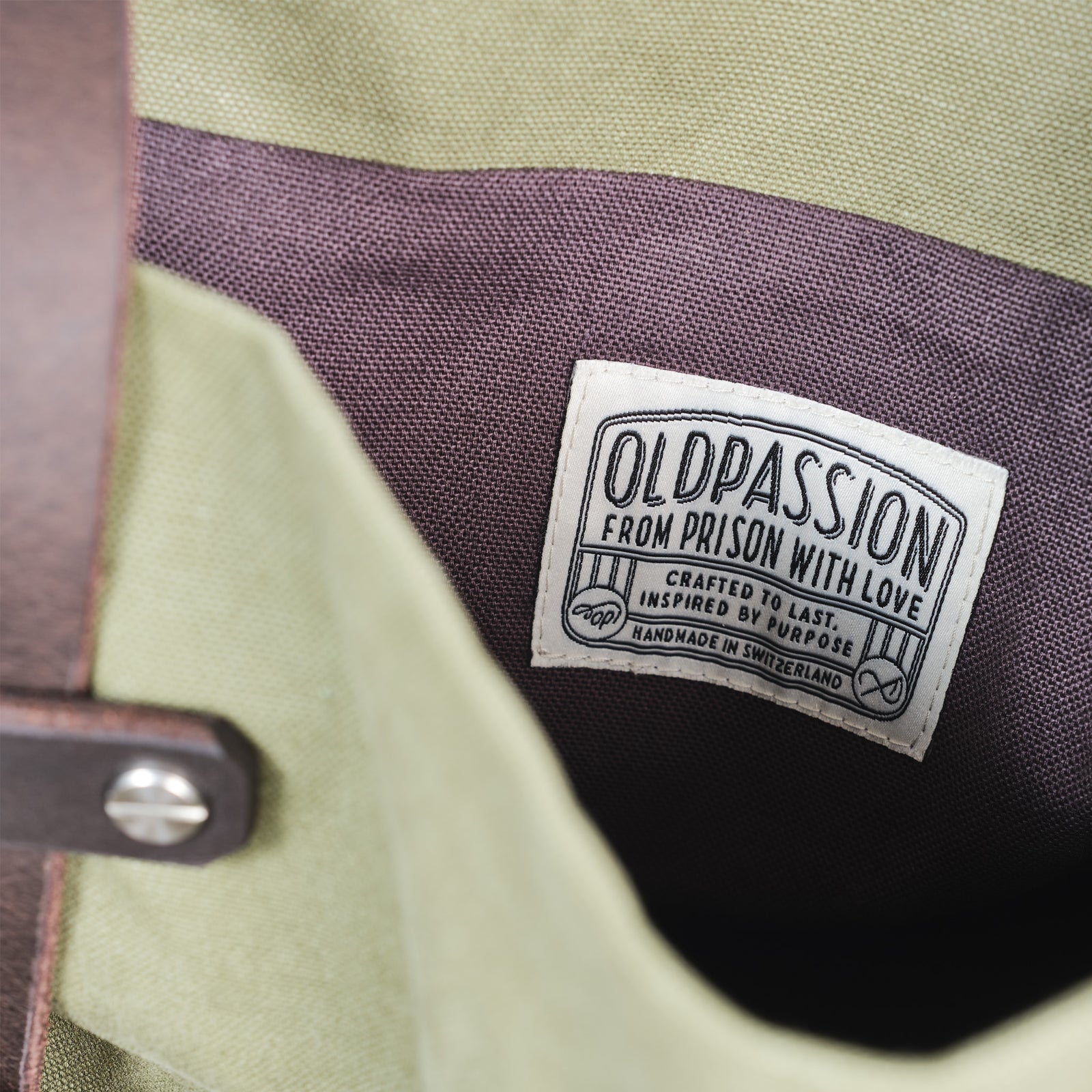 Detailansicht des oldpassion Labels im Innern der Tote Bag Canvas Olive – mit handgefertigtem Charakter und Statement „From Prison with Love“