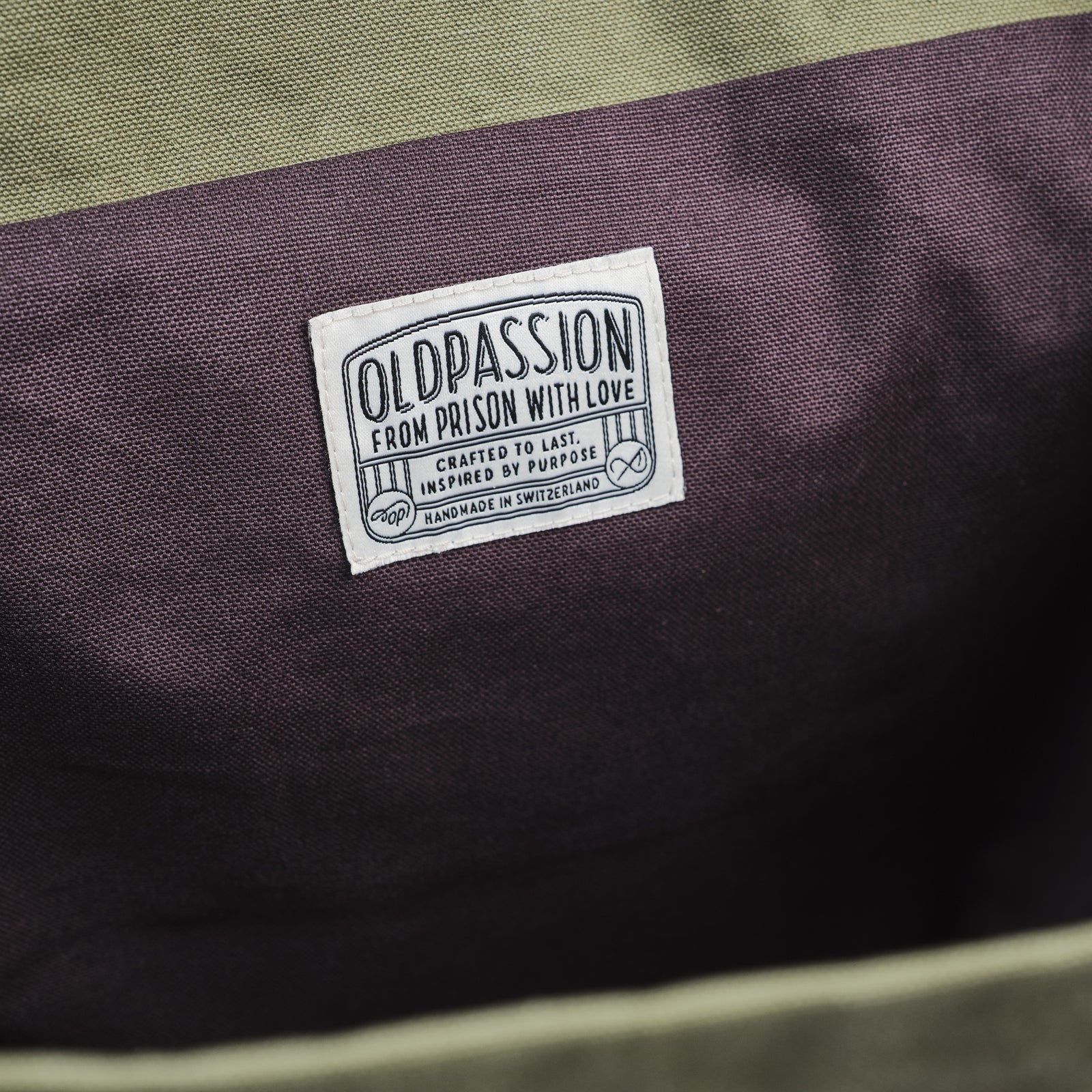 Nahaufnahme des oldpassion Labels im Innern der Canvas Tote – mit Claim "From Prison With Love" und Herkunftsangabe Handmade in Switzerland