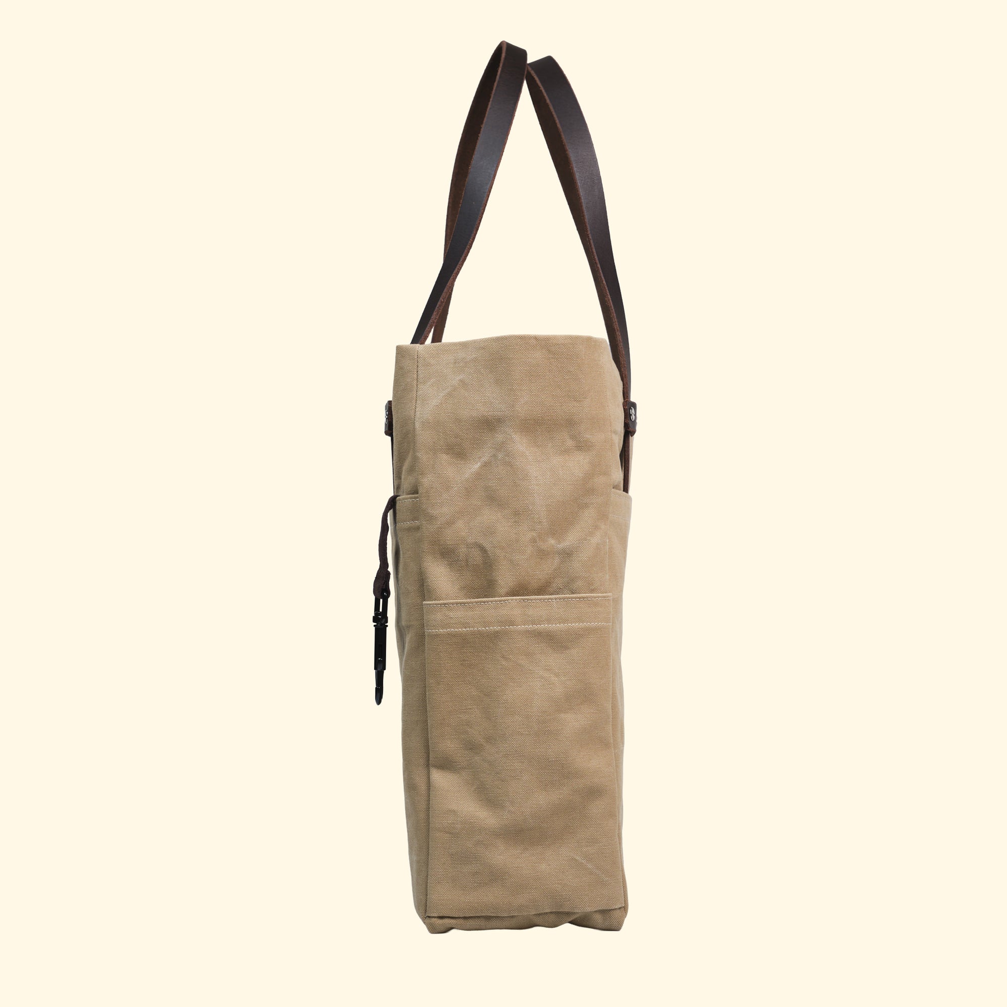Rechte Seitenansicht der Canvas Tote Bag in Sand von oldpassion – mit Karabinerhaken und Außentasche, Swiss Made Handarbeit.